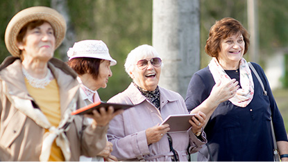 Group of four mature woman travelers standing together outdoors