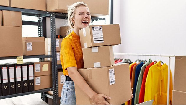Woman excitedly moving boxes in eCommerce storage space