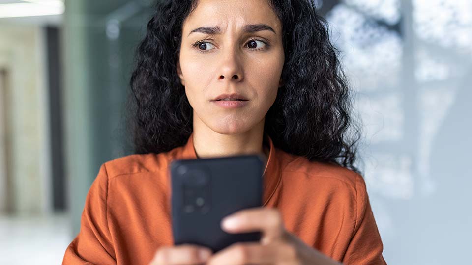 Confused woman holding phone